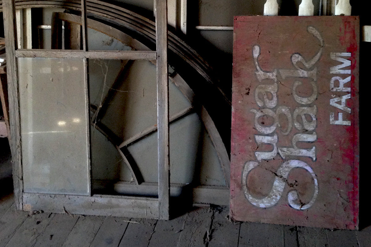 Wooden storage area inside a building with a 'Sugar Shack Farm' sign.